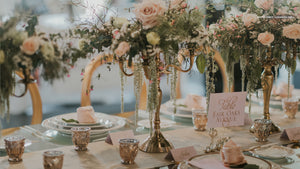 wedding table setup with elegant floral centerpieces and linens in blush and gold